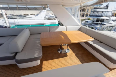 Luxurious seating area on 2017 Princess 68 yacht with wooden table and cushioned benches.