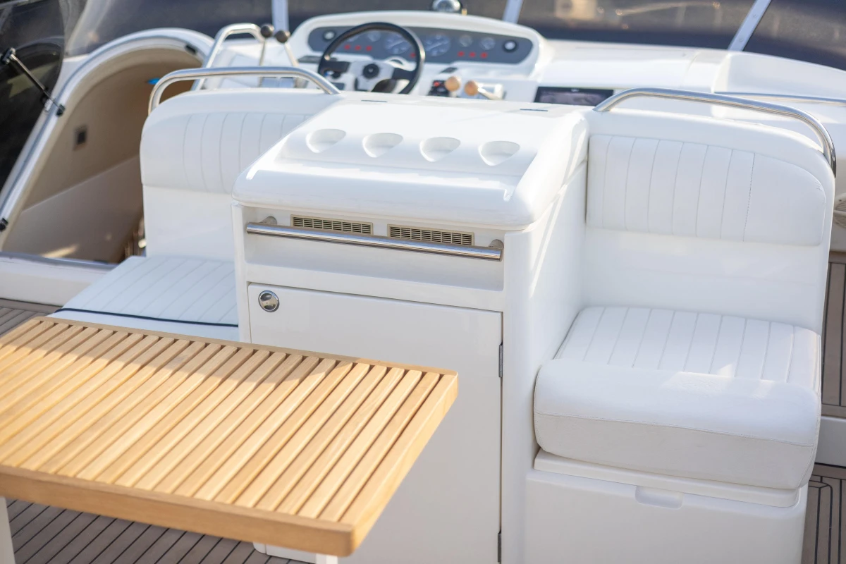 Luxurious 1995 Princess 60 yacht interior with white seating and wooden table.