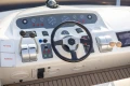 Control panel of a 1995 Princess 60 yacht with steering wheel and navigation instruments.