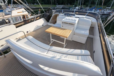 Luxurious 1995 Princess 60 yacht deck with white seating and wooden table.