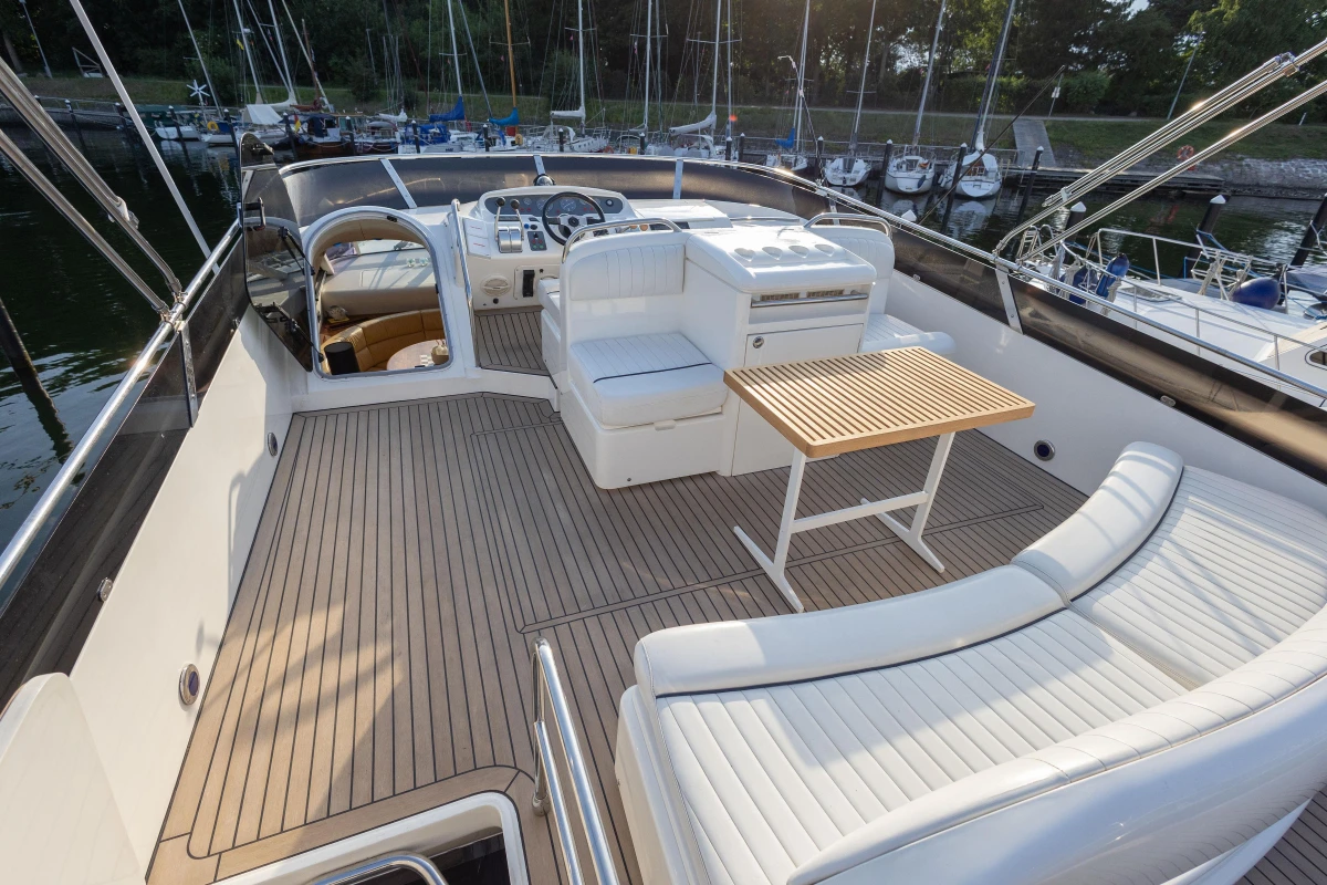 Luxurious 1995 Princess 60 yacht deck with seating and table, docked at marina.