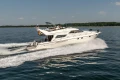 Luxury 1995 Princess 60 yacht cruising on open water, clear sky background.