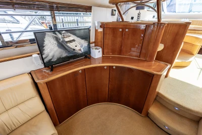 Luxurious interior of a 1995 Princess 60 yacht with wooden cabinetry and a mounted TV.
