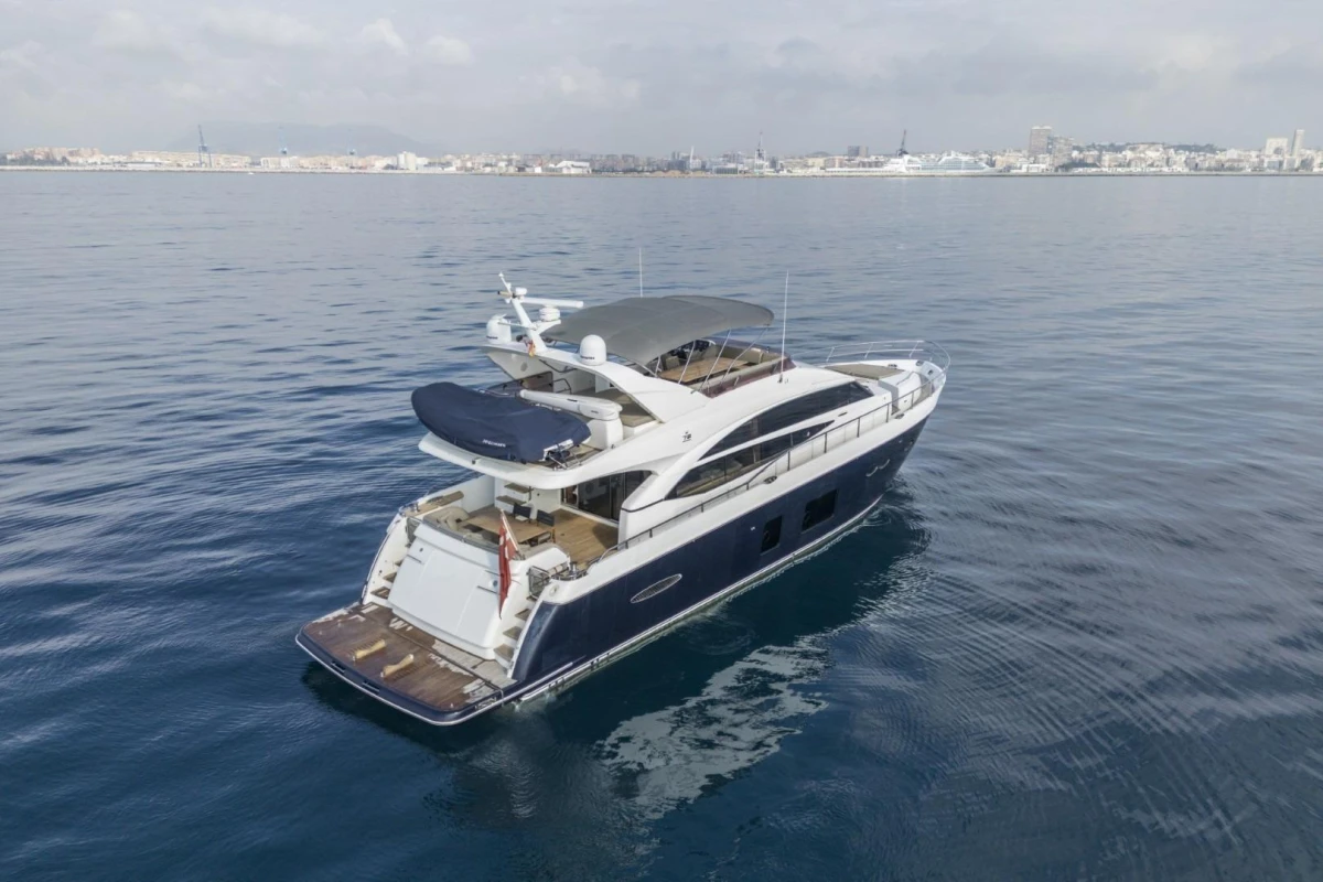 Luxurious 2013 Princess 72 Motor Yacht cruising on calm waters near a coastal city.