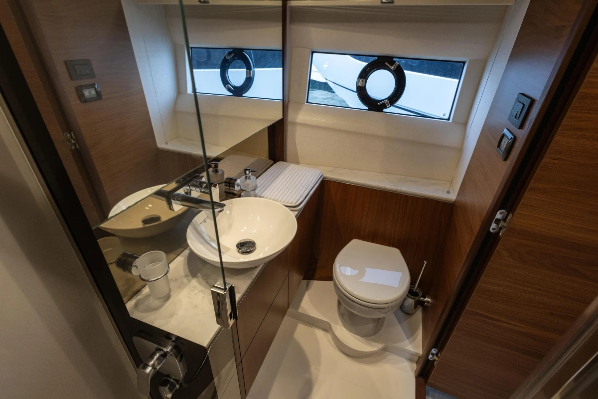 Luxurious bathroom in 2020 Princess F62 yacht with modern fixtures and porthole window.