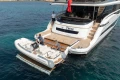 2023 Princess X95 yacht with tender boat on clear blue water.