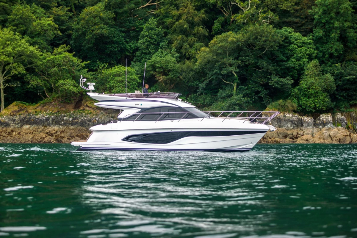 2023 Princess F45 yacht cruising near lush green shoreline.