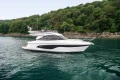 2023 Princess F45 yacht cruising near lush green shoreline.