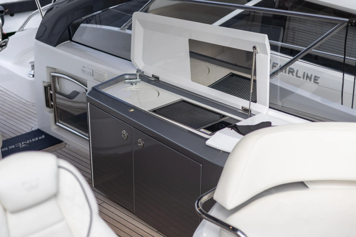 Outdoor kitchen on 2023 Princess V50 Open yacht with grill and sink.