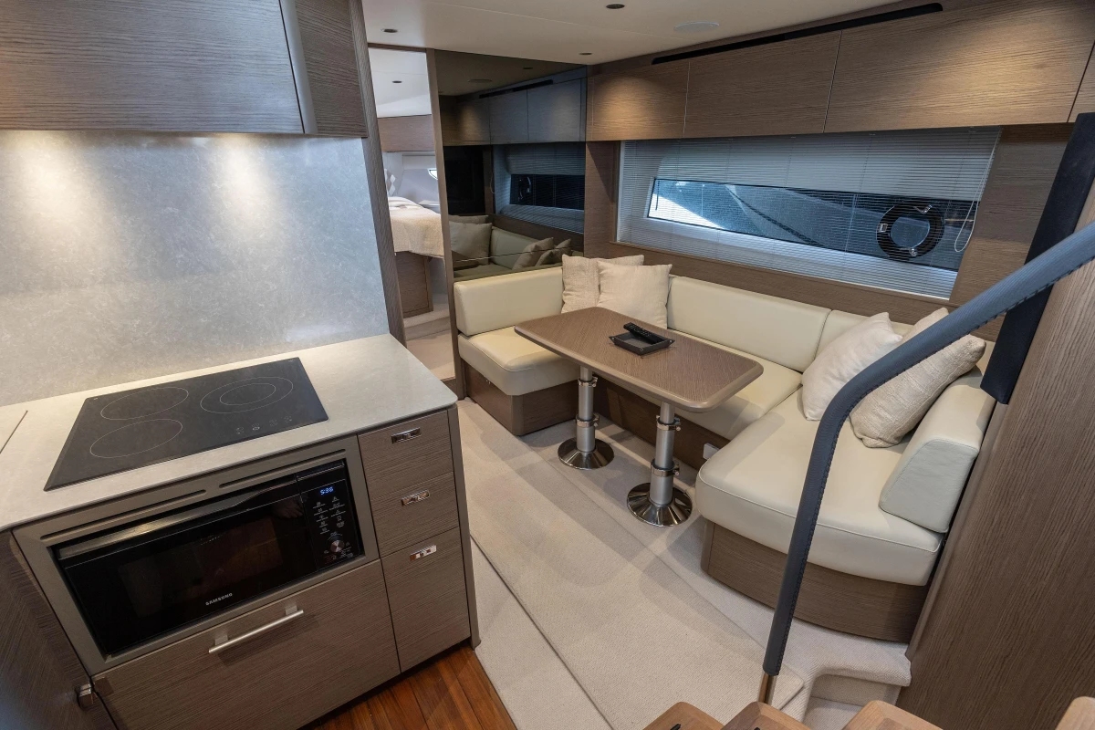 Luxurious interior of 2023 Princess V50 Open yacht with modern kitchen and cozy seating area.