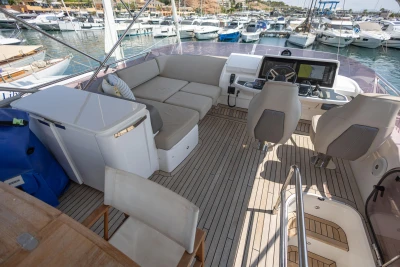Luxurious 2018 Princess 49 yacht interior with seating, helm, and marina view.