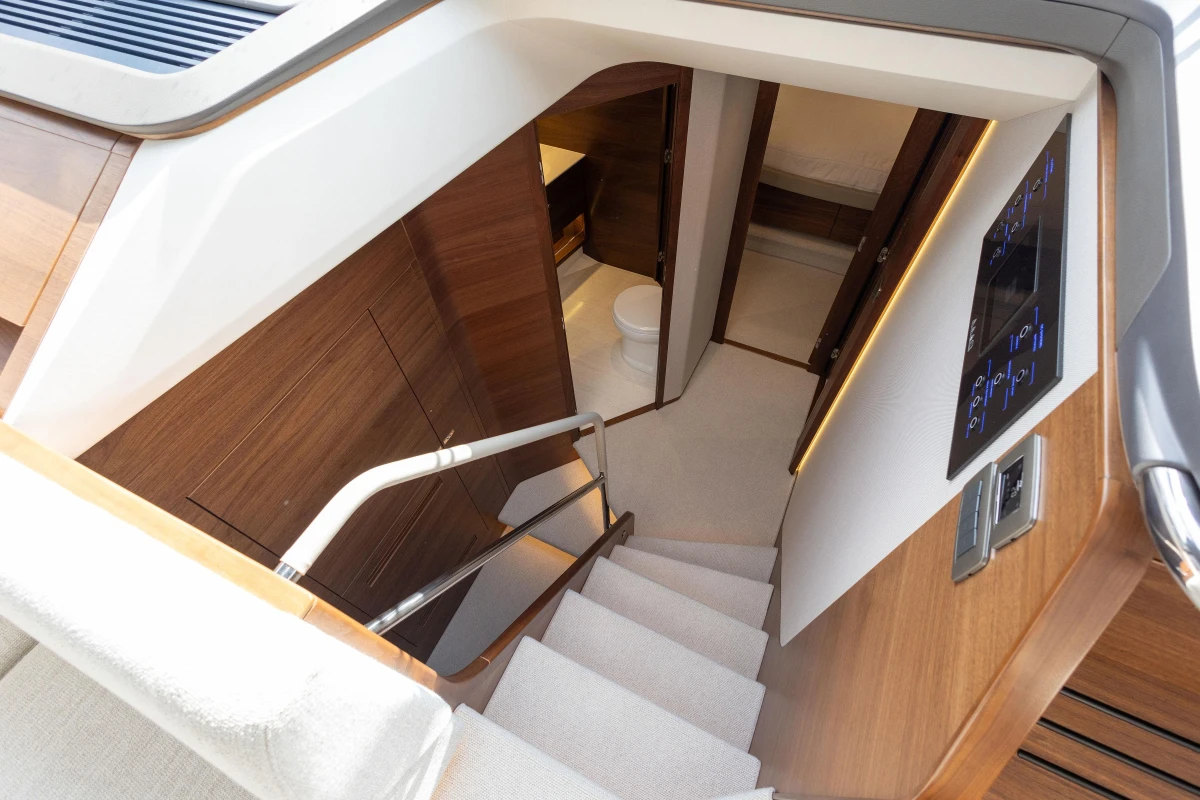 Luxurious interior of 2025 Princess F58 yacht, featuring elegant wooden staircase and modern design.