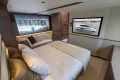 Luxurious bedroom interior of 2025 Princess F58 yacht with modern decor and large window.