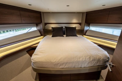 Luxurious 2025 Princess F58 yacht bedroom with elegant wood finishes and modern design.