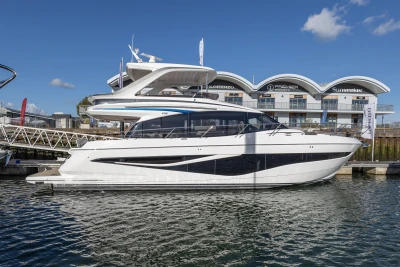 2025 Princess F58 yacht docked at marina, clear sky, modern architecture in background.