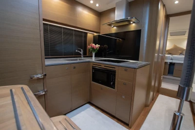 Luxurious kitchen interior of 2017 Princess V48 Open yacht, featuring modern appliances and elegant wood finish.