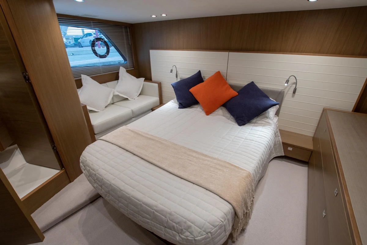 Luxurious cabin interior of 2017 Princess V48 Open yacht with cozy bed and seating area.