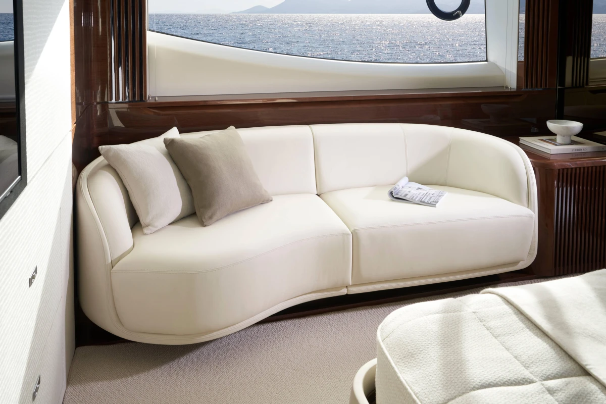 Luxurious interior of 2026 Princess X80 yacht with elegant white sofa and ocean view.